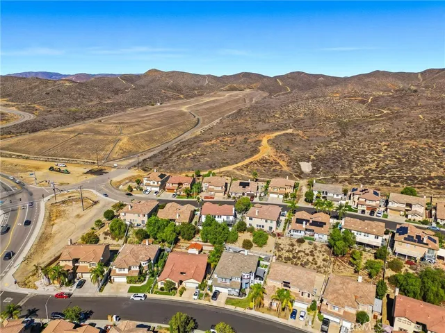 an aerial view of residential houses with outdoor space and trees