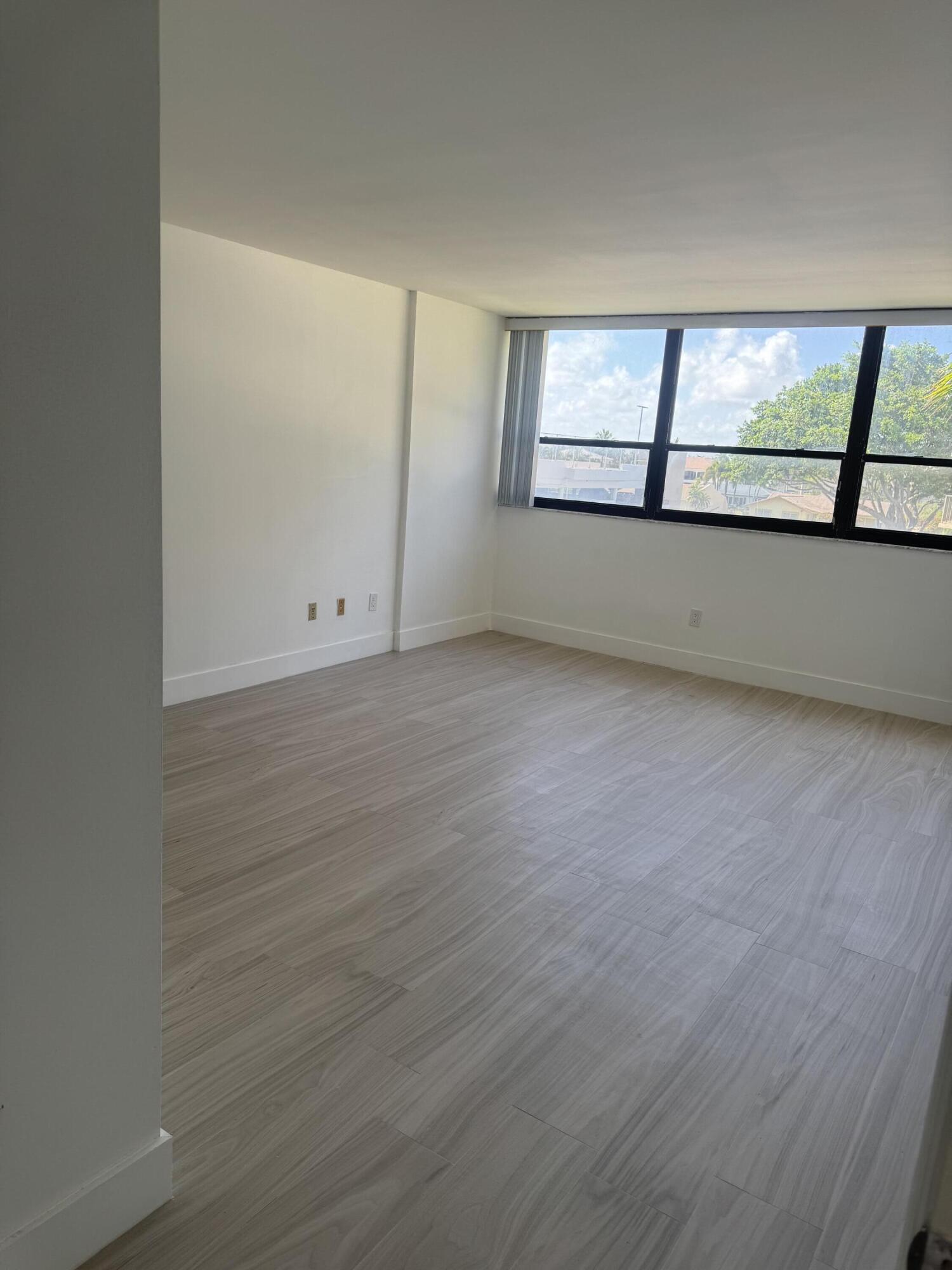 859 Jeffery Street, Unit 312 Boca Raton, FL 33487 - Photo 18 of 53 an empty room with wooden floor and windows