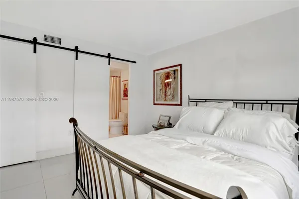 a bedroom with a bed and a painting on the wall