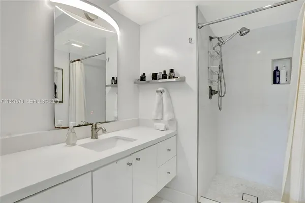 a bathroom with a double vanity sink mirror and shower