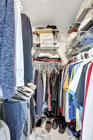 a view of walk in closet with clothes and shoes