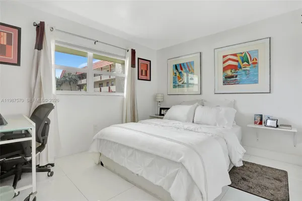 a bedroom with a bed and a painting on the wall