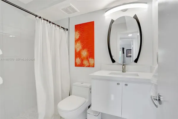 a bathroom with a toilet sink vanity and mirror