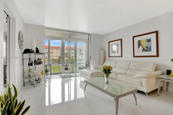 a living room with furniture and floor to ceiling windows
