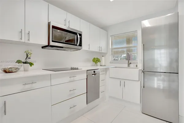 a kitchen with appliances a sink and cabinets