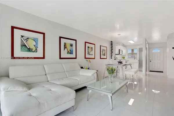 a living room with furniture and a dining table with kitchen view