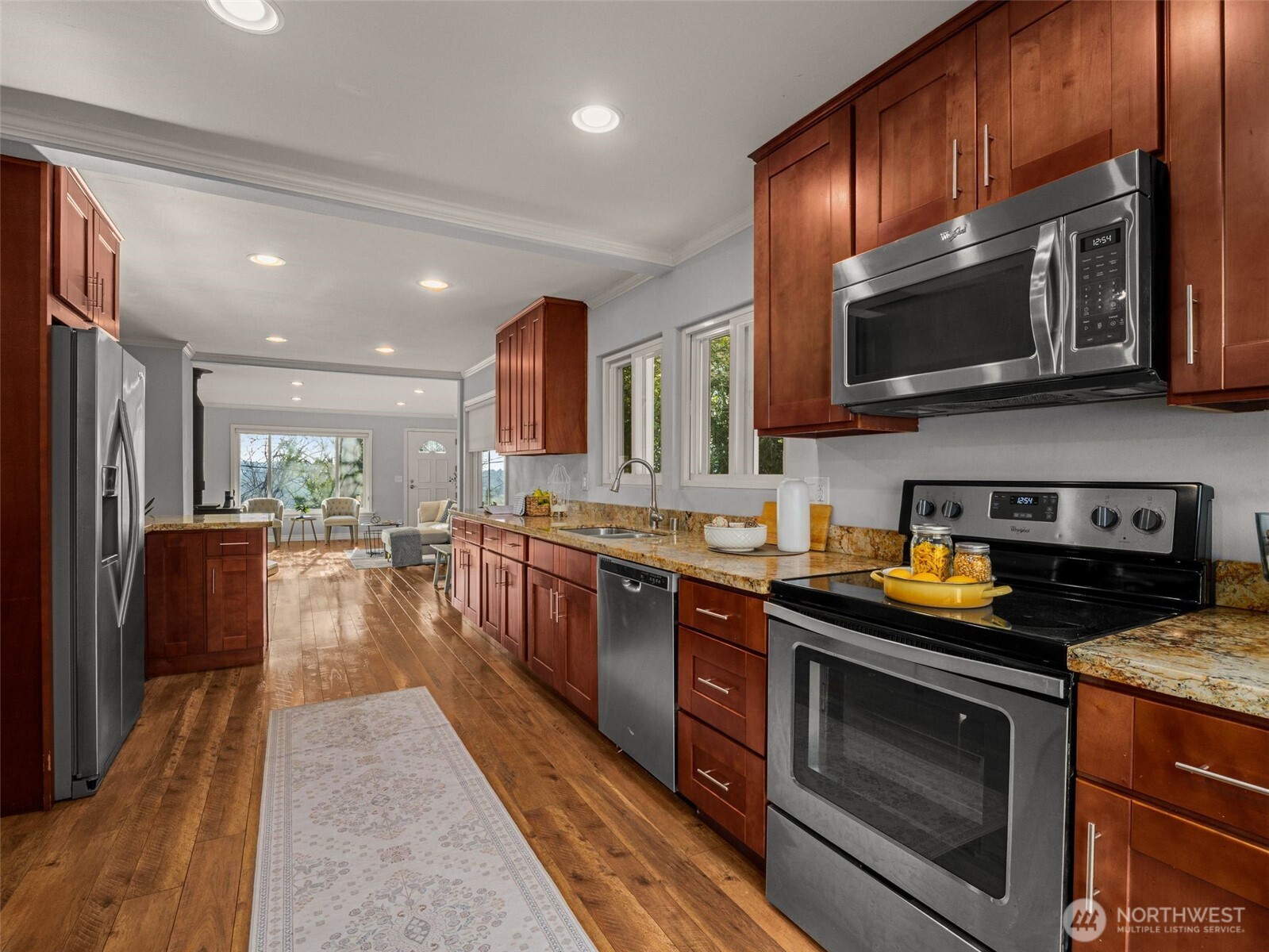 3928 South Pilgrim Street Seattle, WA 98118 - Photo 11 of 27 a kitchen with stainless steel appliances granite countertop wooden cabinets a stove top oven a sink and dishwasher