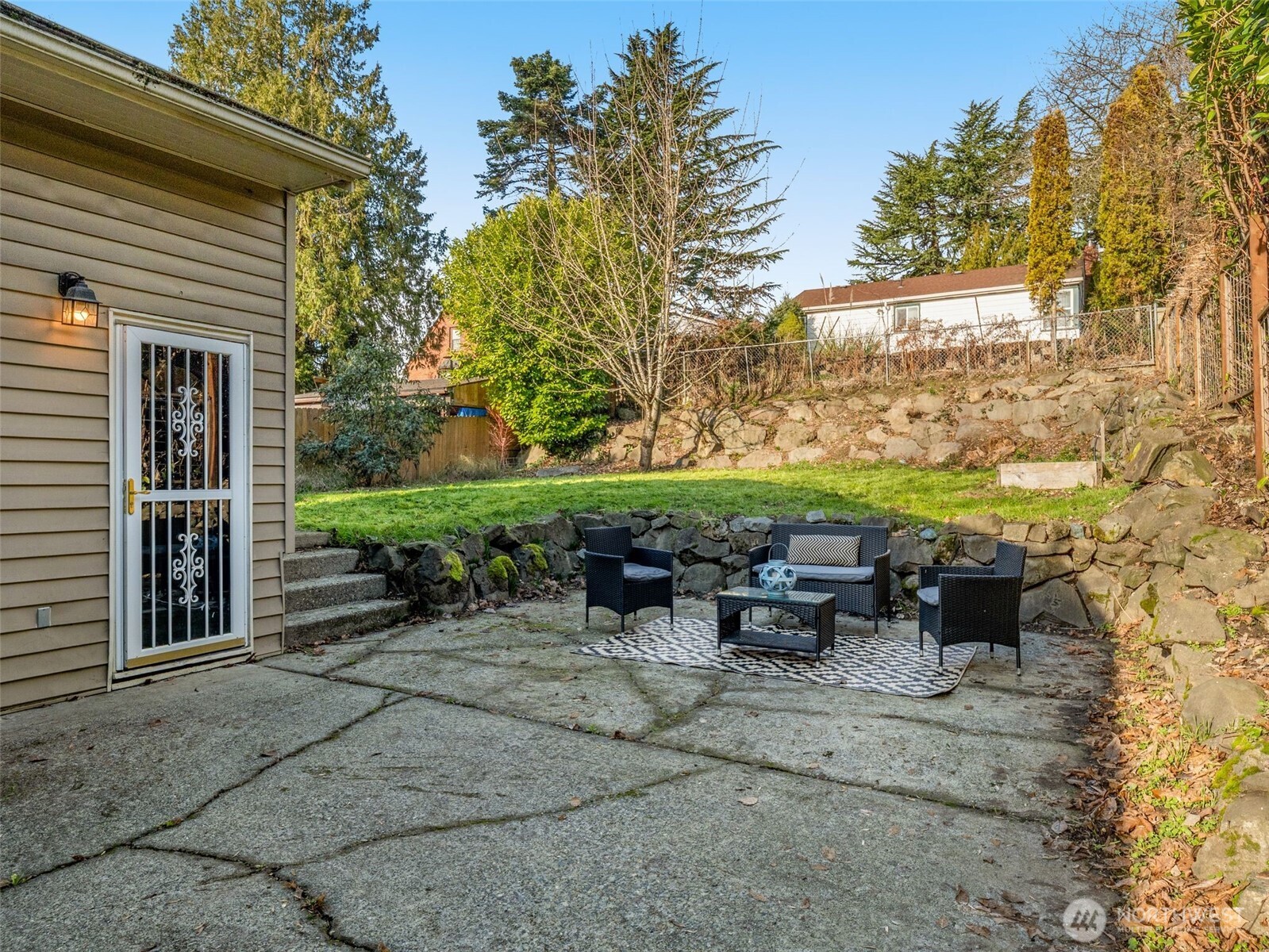 3928 South Pilgrim Street Seattle, WA 98118 - Photo 23 of 27 a view of a patio with table and chairs potted plants and floor to ceiling window
