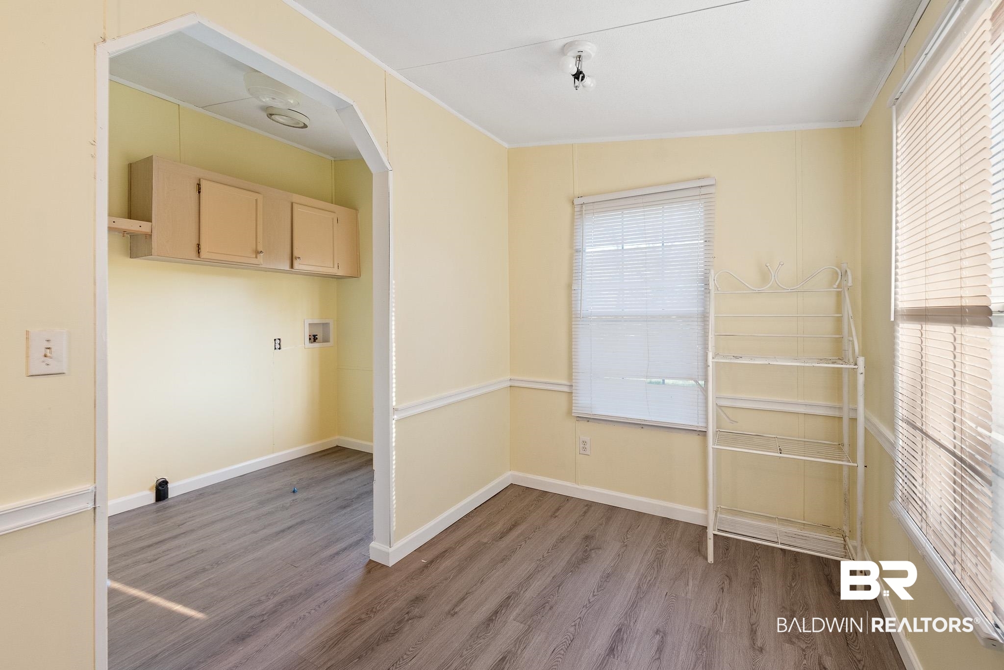 7695 Bermuda Drive Semmes, AL 36575 - Photo 14 of 27 Laundry area with baseboards, washer hookup, wood finished floors, arched walkways, and cabinet space