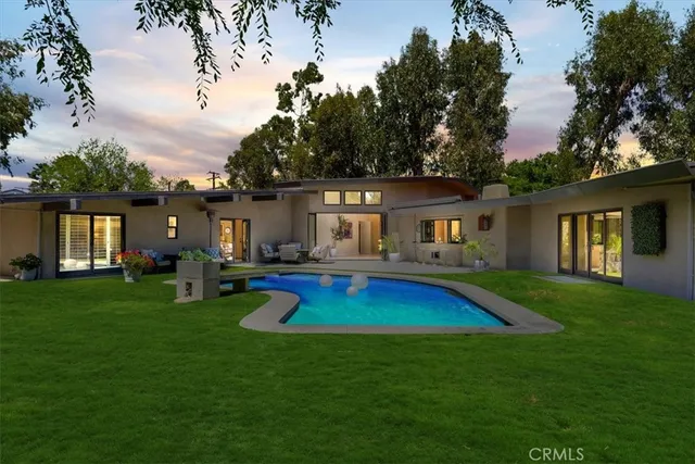 a view of house with swimming pool yard and outdoor seating