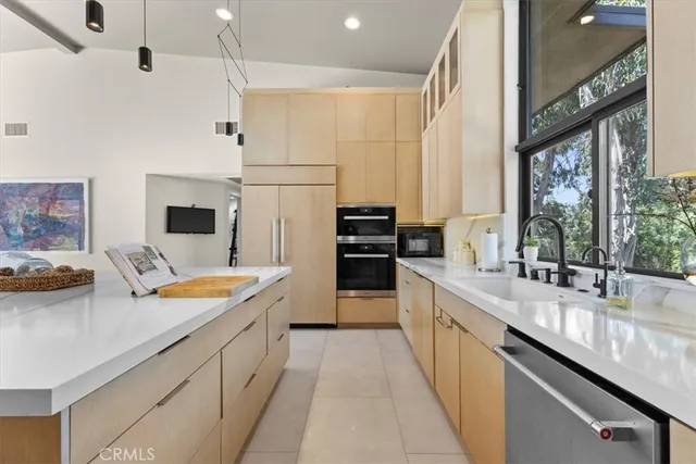 a dining hall with stainless steel appliances granite countertop a stove a sink a dining table and chairs with wooden floor