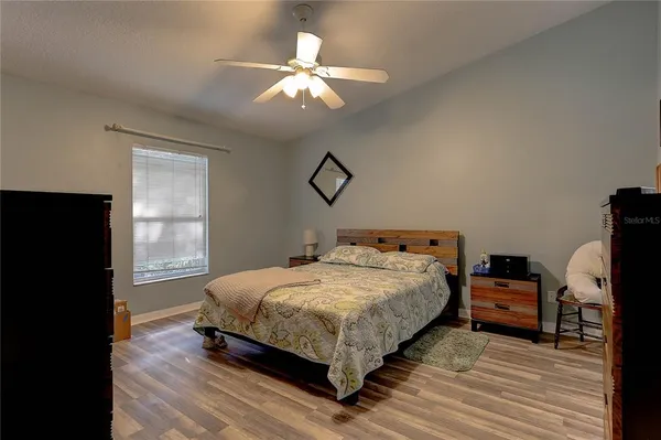 a bedroom with a bed and wooden floor