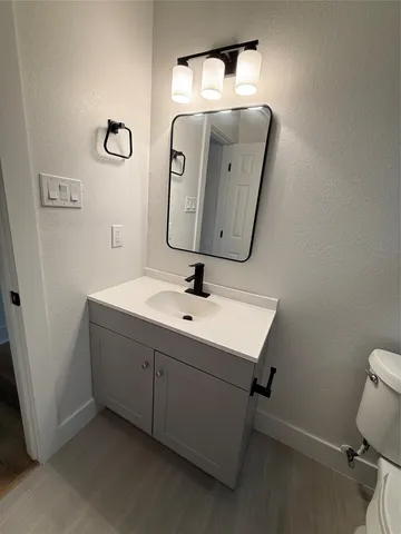 a bathroom with a sink and mirror with toilet