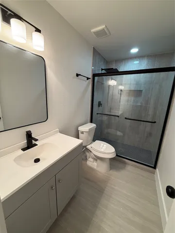 a bathroom with a sink mirror toilet and shower