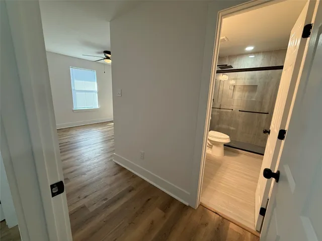 an empty room with wooden floor and mirror
