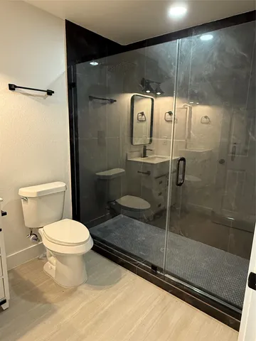 a bathroom with a toilet and a shower