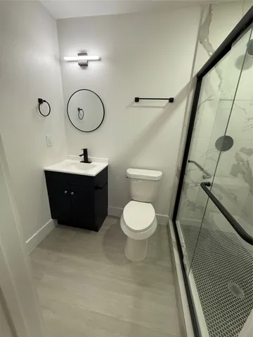a bathroom with a toilet a sink and mirror