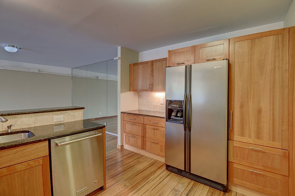 40 North Interstate Highway 35, Unit 2C2 Austin, TX 78701 - Photo 9 of 35 a kitchen with wooden cabinets and stainless steel appliances