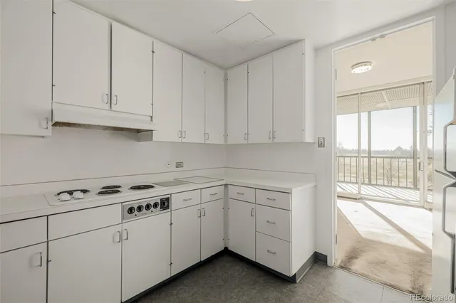 a kitchen with white cabinets and a stove