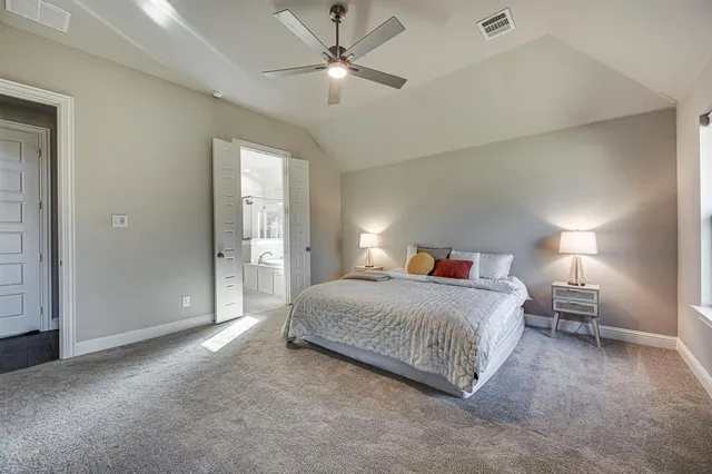 a spacious bedroom with a bed and a chandelier