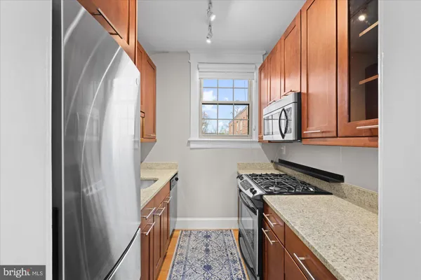 a kitchen with stainless steel appliances granite countertop a stove a sink and a refrigerator