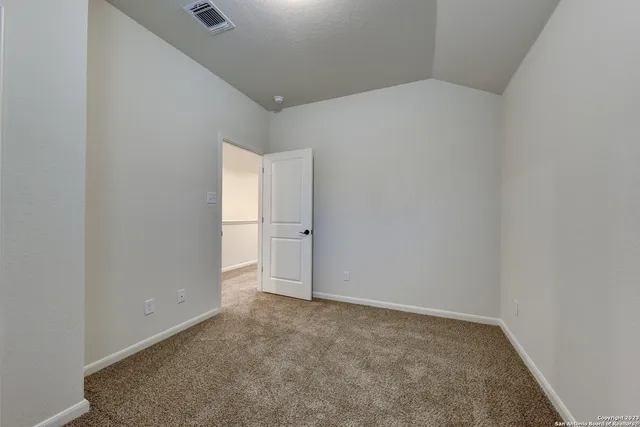 a view of an empty room with closet and a window