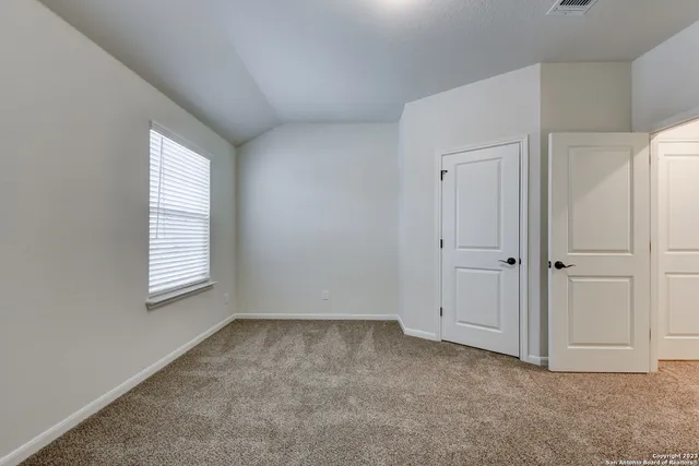 an empty room with windows and closet