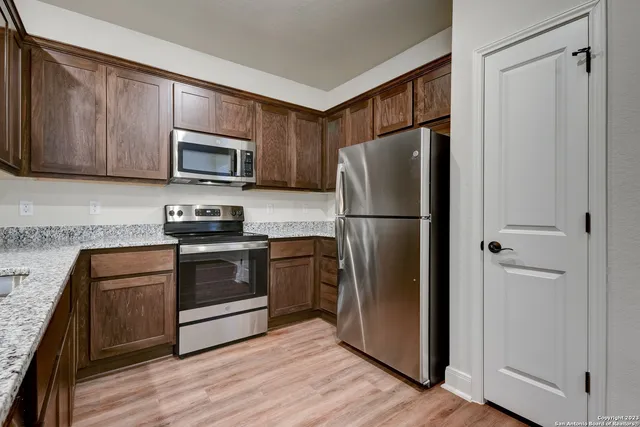 a kitchen with stainless steel appliances granite countertop a refrigerator stove and microwave