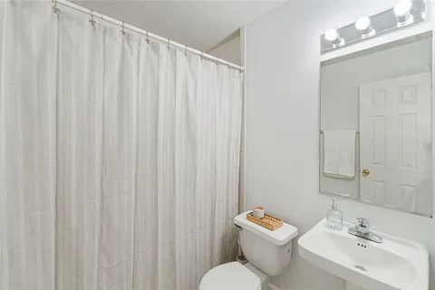 a bathroom with a sink a toilet and a mirror