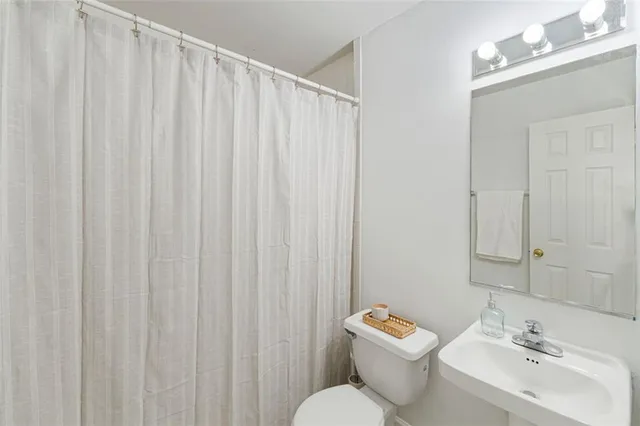 a bathroom with a sink a toilet and a mirror