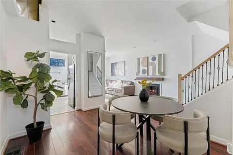 a view of a dining room with furniture a potted plant and wooden floor