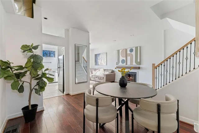 a view of a dining room with furniture a potted plant and wooden floor