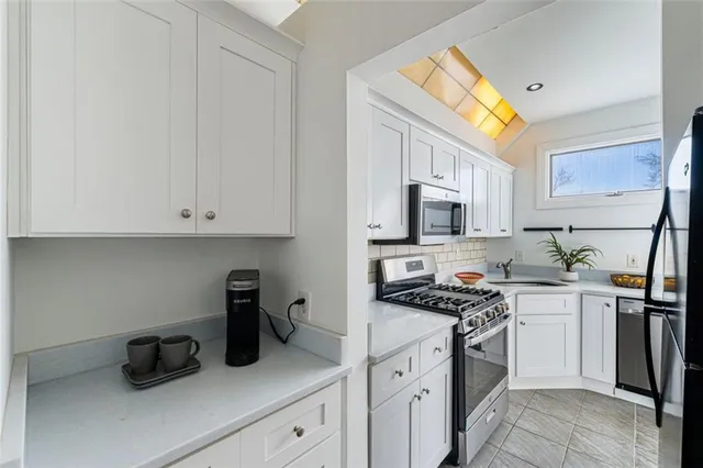 a kitchen with cabinets appliances a sink and a counter top space