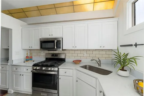a kitchen with a sink a stove cabinets and appliances