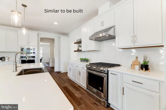 a kitchen with stainless steel appliances a stove a sink and cabinets