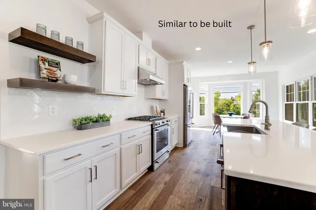 a large white kitchen with stainless steel appliances