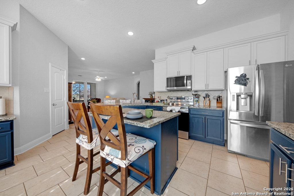 400 Bison Lane Cibolo, TX 78108 - Photo 11 of 34 a kitchen with stainless steel appliances granite countertop a table and a refrigerator