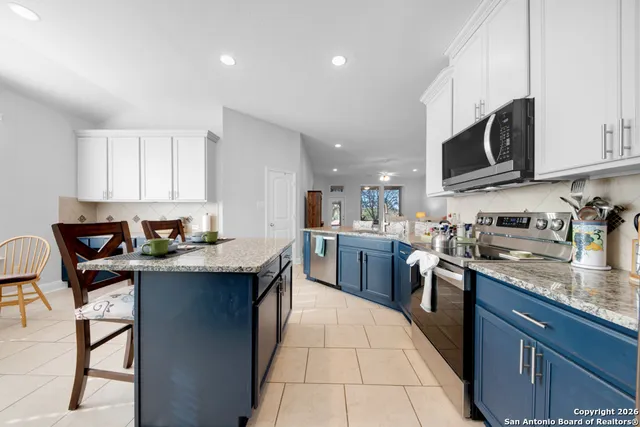 a kitchen with stainless steel appliances granite countertop a sink a stove top oven a counter space and cabinets