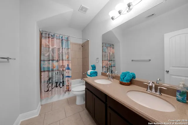 a bathroom with a granite countertop sink a toilet and a mirror