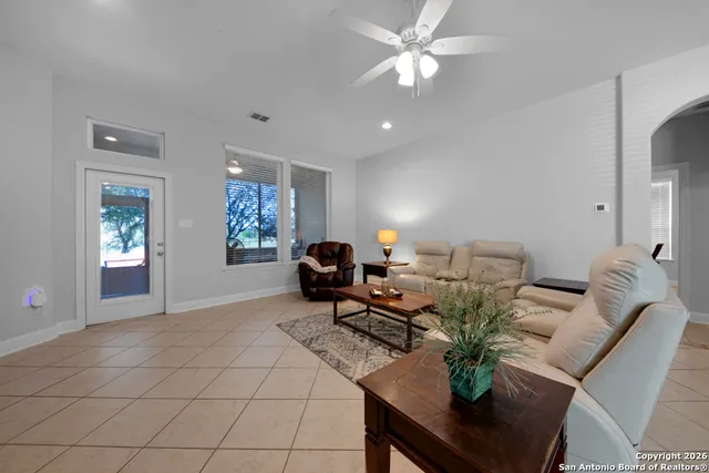 a living room with furniture a chandelier and a window