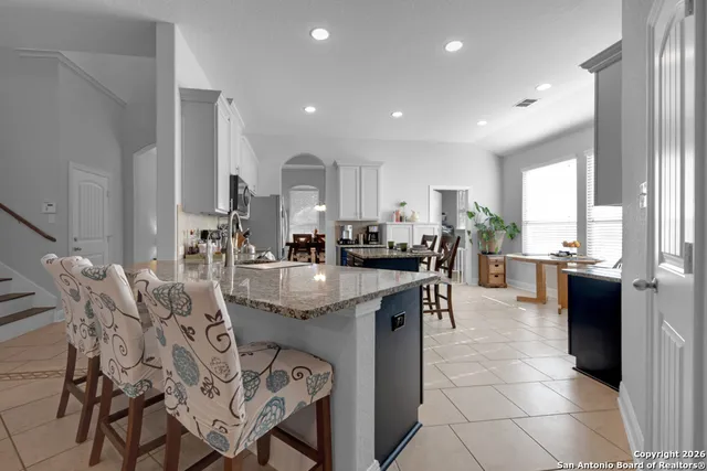 a kitchen with stainless steel appliances granite countertop table chairs sink and cabinets