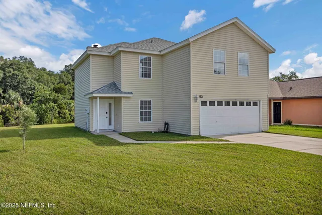 a front view of a house with a yard and garage