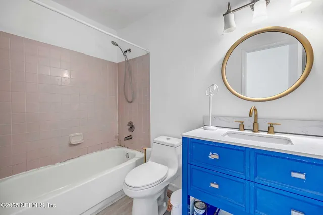 a bathroom with a bathtub shower sink mirror and toilet