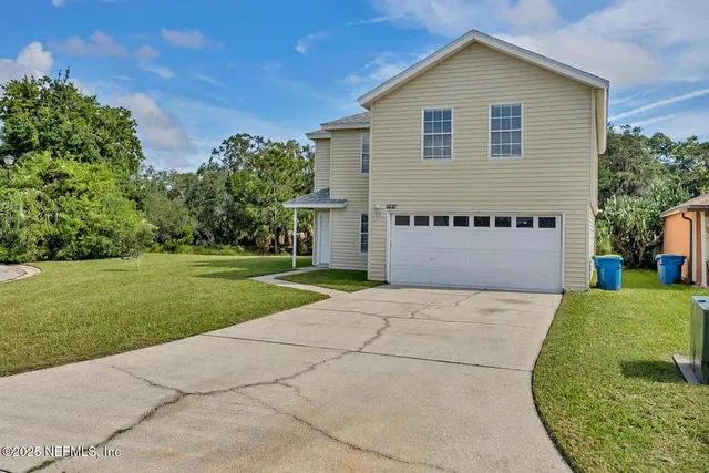 a front view of a house with a yard and garage