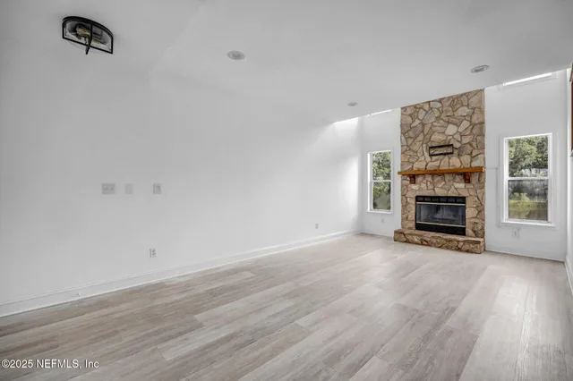 wooden floor fireplace and natural light in room