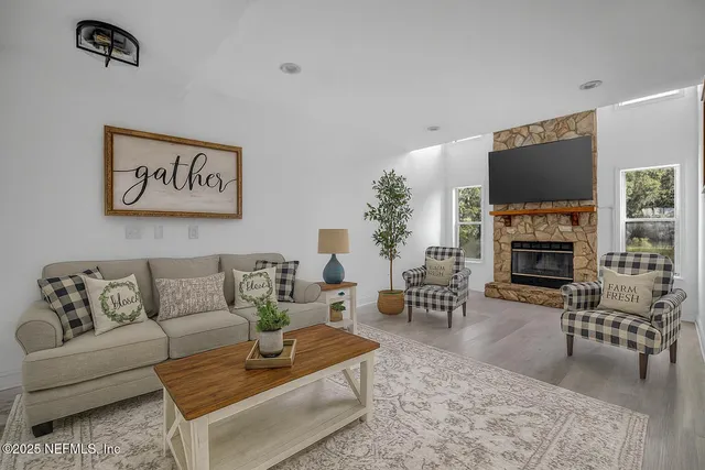 a living room with furniture a flat screen tv and a fireplace