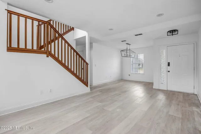 a view of a livingroom with wooden floor and staircase