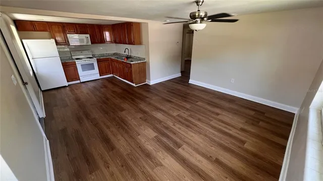a kitchen with stainless steel appliances a refrigerator and wooden floor