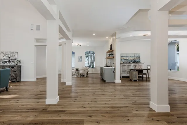 a kitchen that has a sink a stove and wooden floor