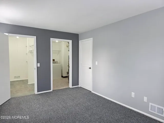 an empty room with closet and a bathroom